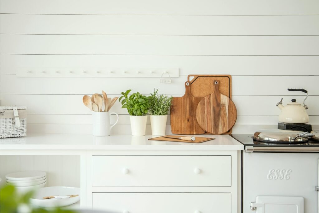 potted herbs, cutting boards, and various kitchen decor in a white kitchen on the counter