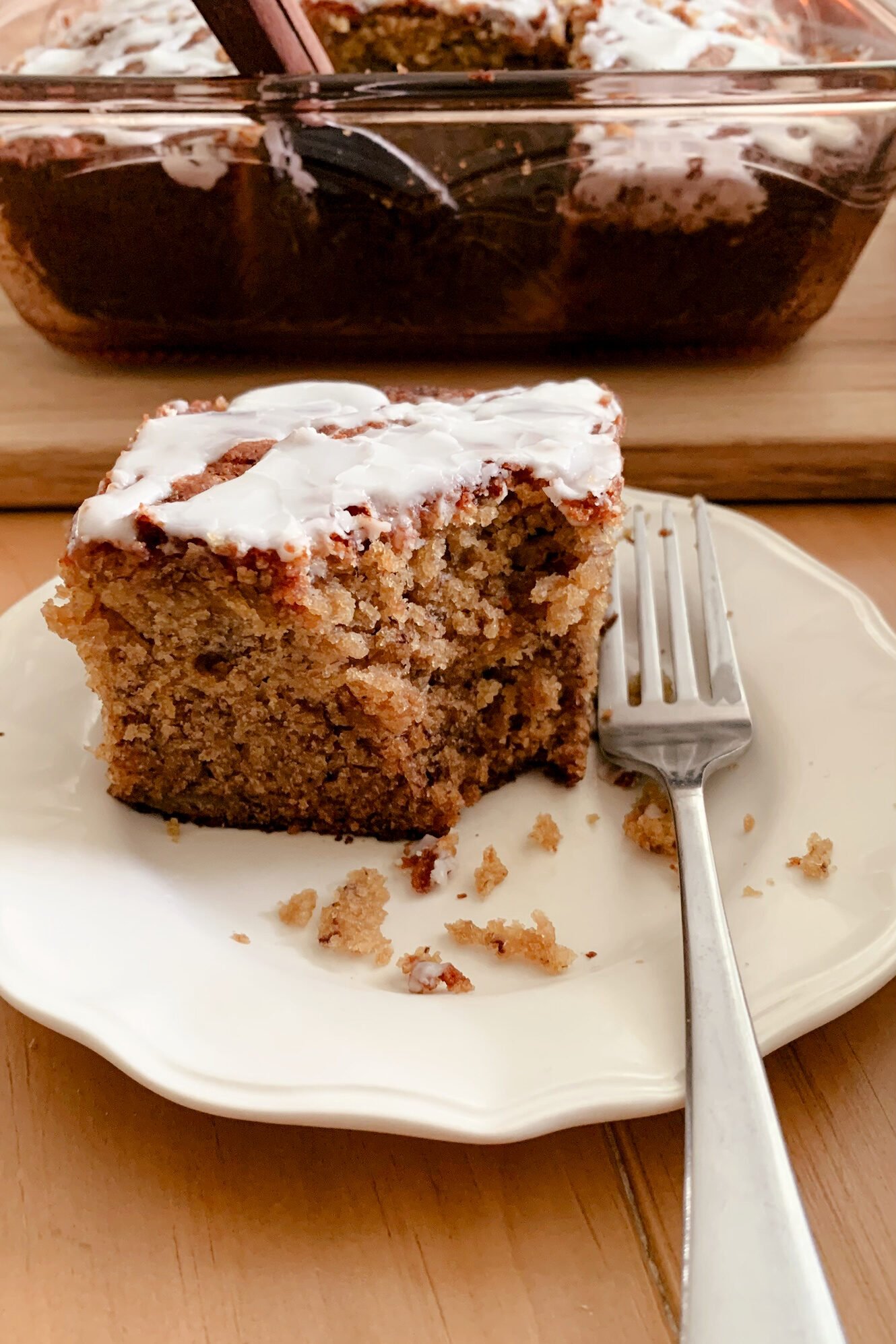 A close up view of a slice of fresh milled banana bread coffee cake on a plate with a fork
