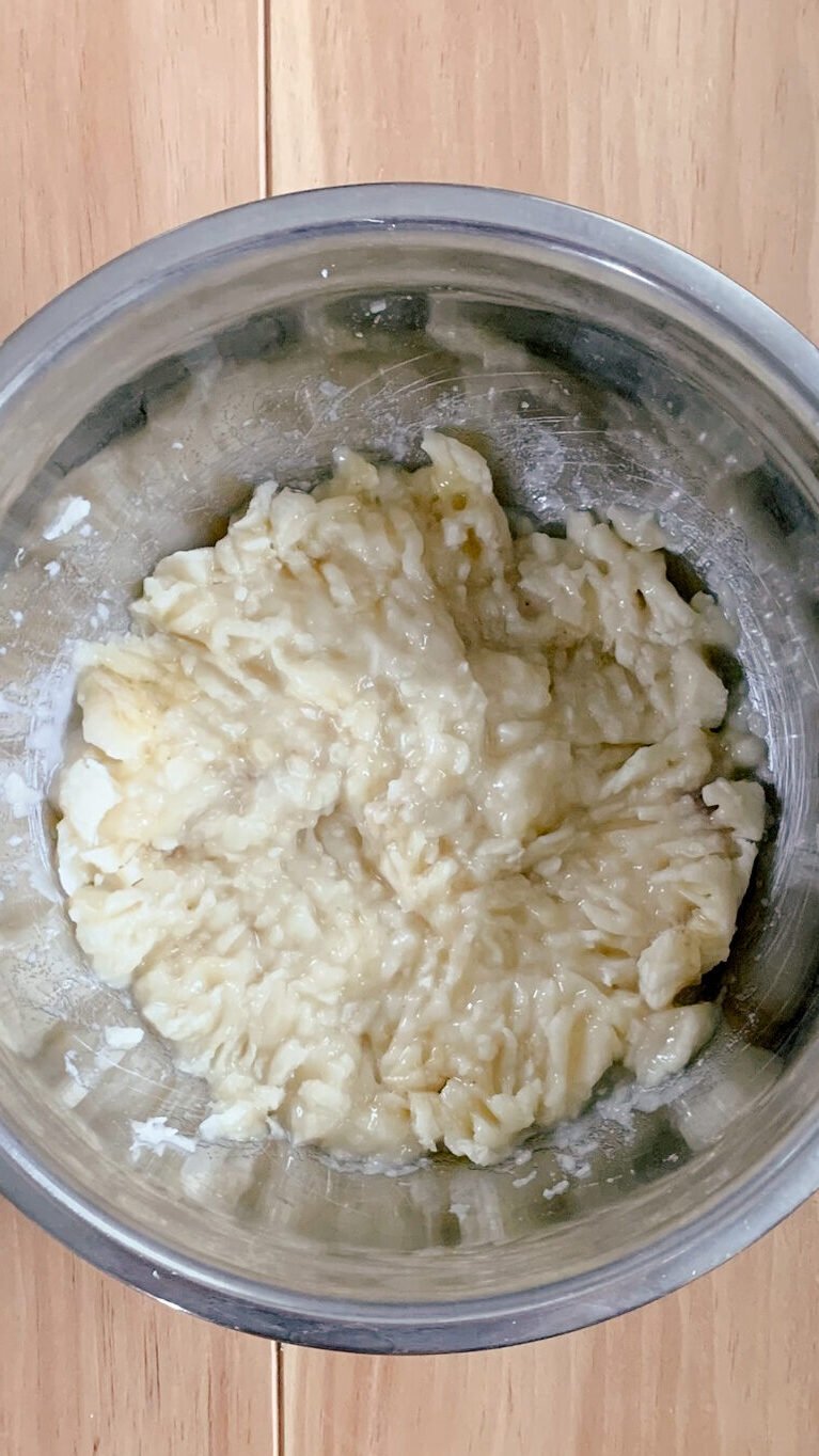 A stainless steel bowl of mashed bananas