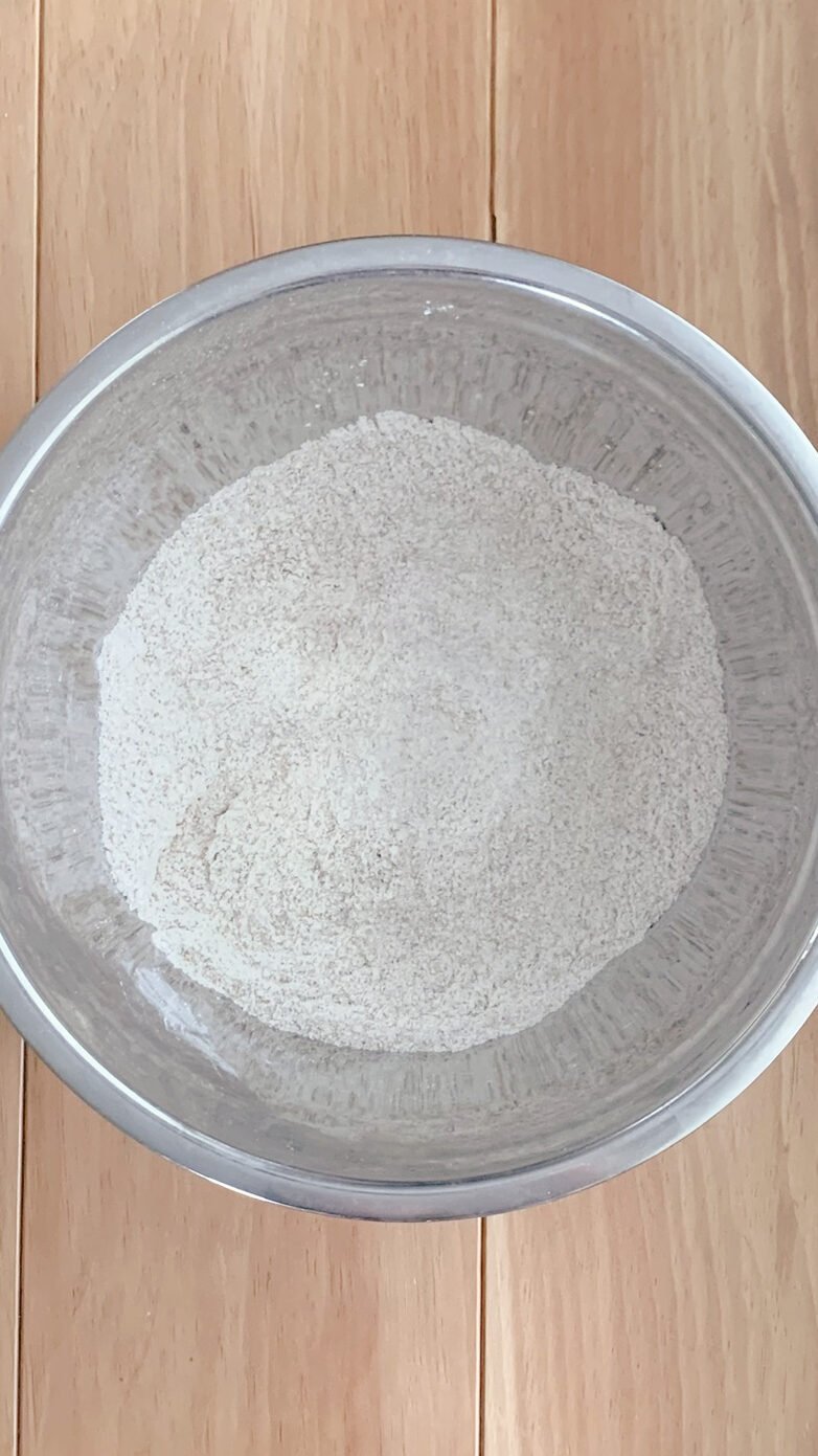 Dry ingredients for fresh milled banana bread coffee cake mixed together in a stainless steel bowl