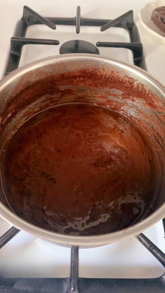 Ingredients for the icing for fresh milled Texas sheet cake on the stove in a saucepan after boiling