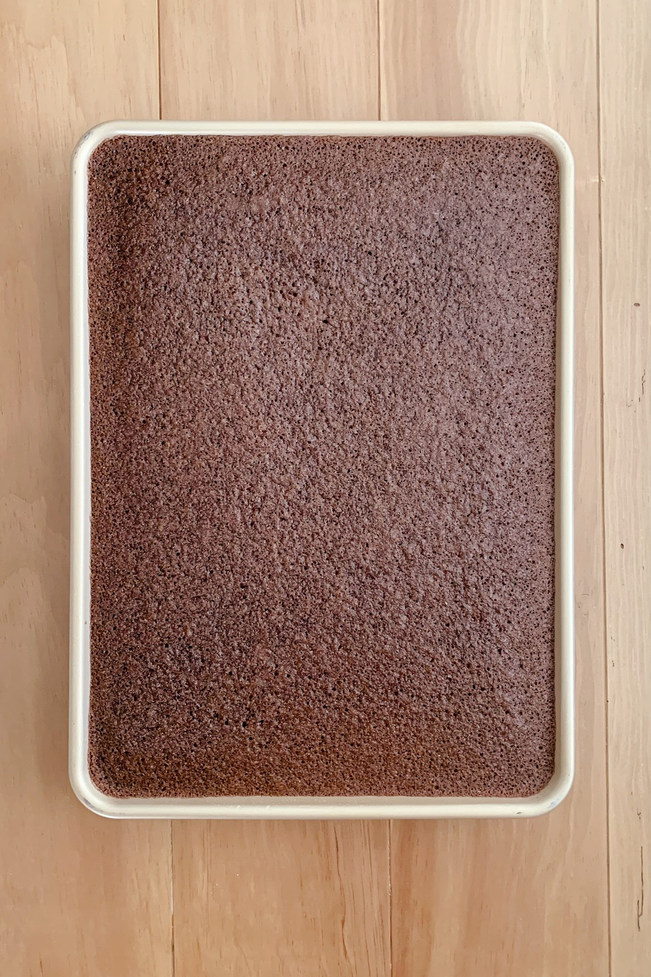 A fresh milled Texas sheet cake after baking in the oven and resting on a wooden table