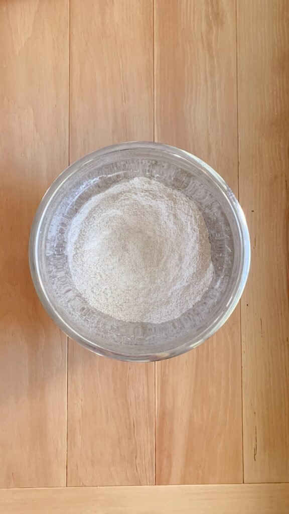 A bowl of dry ingredients for fresh milled cherry coffee cake on a wooden surface
