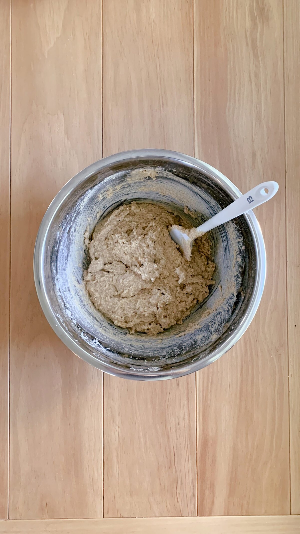 The batter for fresh milled cherry coffee cake on a wooden surface