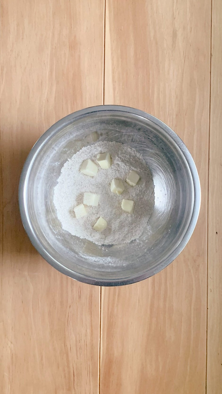 The fresh milled soft white wheat flour and sugar with the cut up cubes of butter for fresh milled cherry coffee cake, on a wooden surface