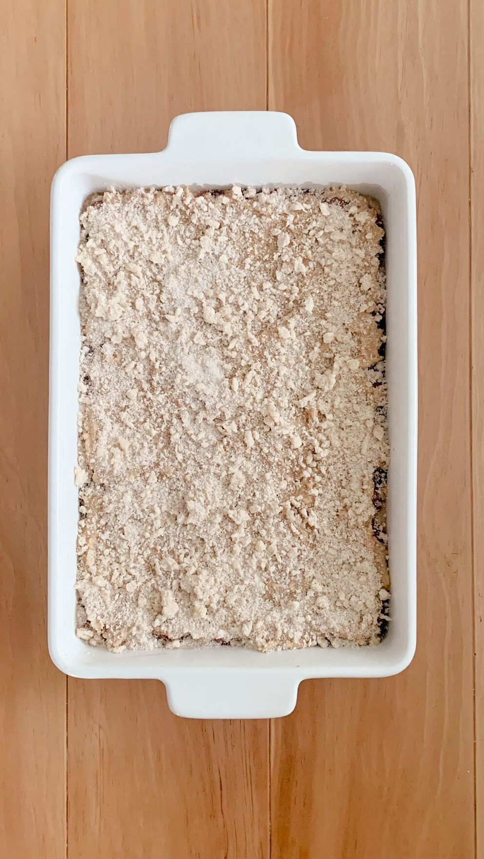 Fresh milled cherry coffee cake ready to be baked, on a wooden surface