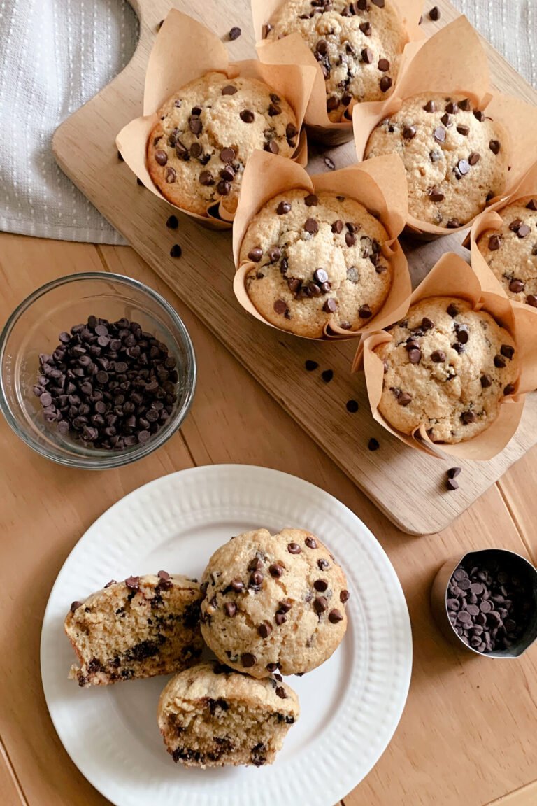 fresh milled chocolate chip muffins on a cooling rack with a tea towel underneath